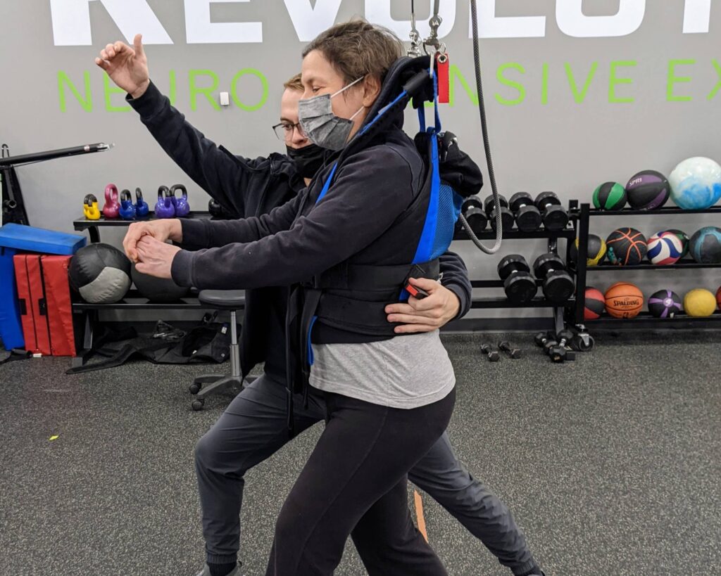 Client practicing walking on the body weight support track