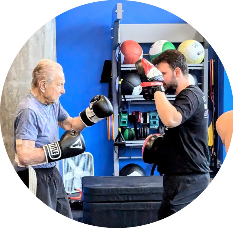 A Neuro Exercise Specialist coaching a client through non-contact boxing